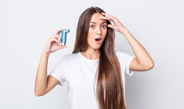 Mujer bonita joven que parece feliz, asombrada y sorprendida. concepto de asma