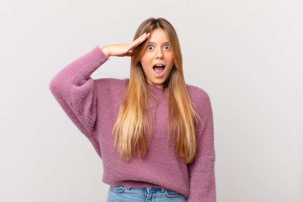 Mujer bonita joven que parece feliz, asombrado y sorprendido