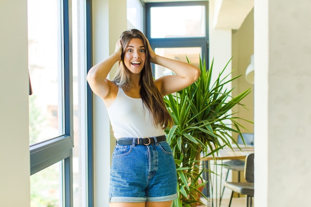 Mujer bonita joven que parece feliz, despreocupada, amigable y relajada disfrutando de la vida y el éxito, con una actitud positiva