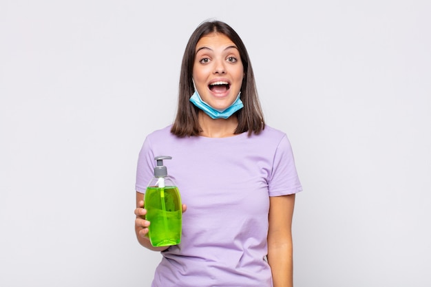 Mujer bonita joven que parece feliz y gratamente sorprendida, emocionada con una expresión fascinada y conmocionada