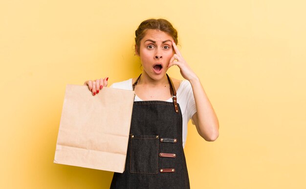 Mujer bonita joven que parece sorprendida al darse cuenta de una nueva idea o concepto de pensamiento concepto de mensajería de comida rápida