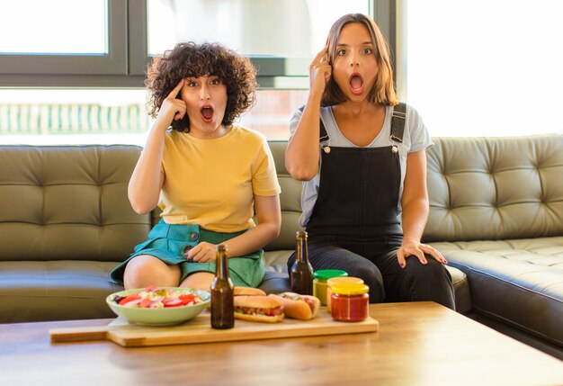 Mujer bonita joven que parece sorprendida, con la boca abierta, conmocionada, dándose cuenta de un nuevo pensamiento, idea o concepto