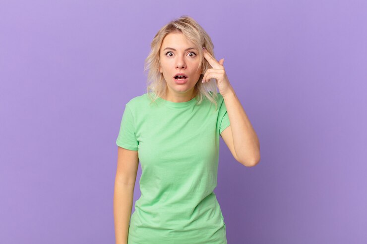 Foto mujer bonita joven que parece sorprendida, dándose cuenta de un nuevo pensamiento, idea o concepto