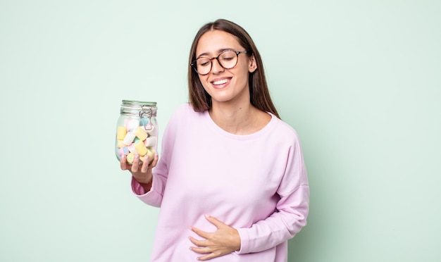 Foto mujer bonita joven que se ríe a carcajadas de una broma hilarante. concepto de caramelos de gelatina