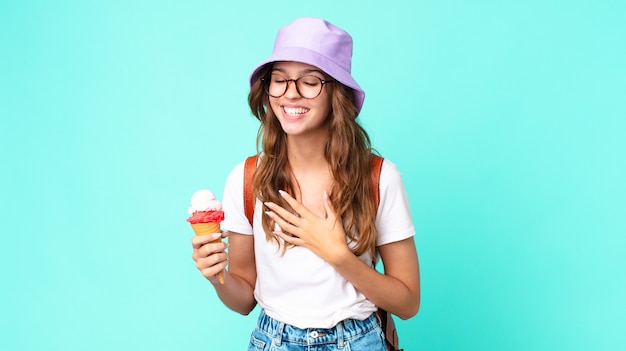 Mujer bonita joven que se ríe a carcajadas de una broma hilarante con un helado. concepto de verano