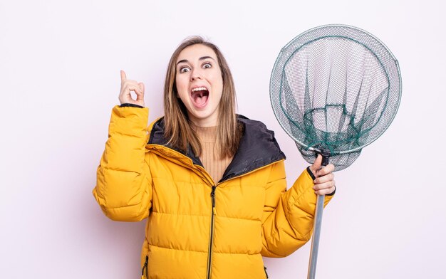 Mujer bonita joven que se siente como un genio feliz y emocionado después de realizar una idea. concepto de pescador