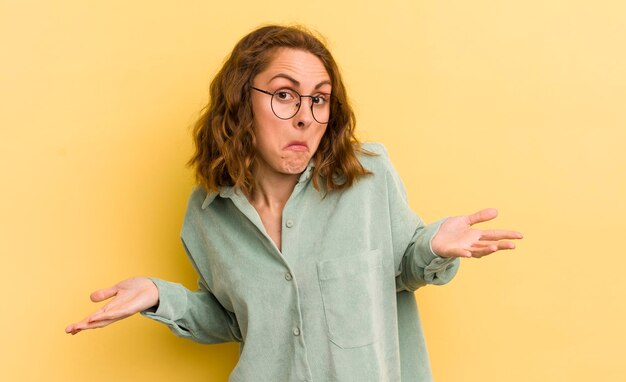 Foto mujer bonita joven que se siente despistada y confundida sin tener idea absolutamente desconcertada con una mirada tonta o tonta