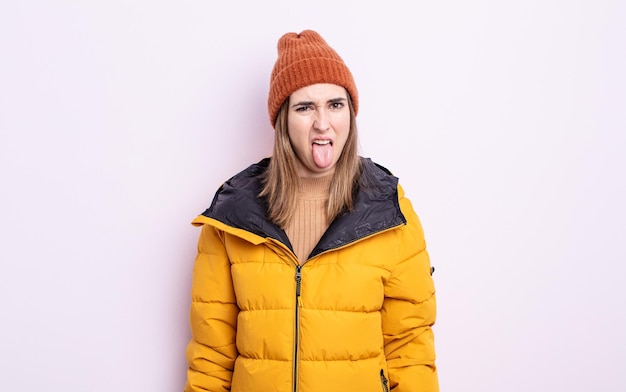 Mujer bonita joven que se siente disgustada e irritada y con la lengua fuera. concepto de invierno