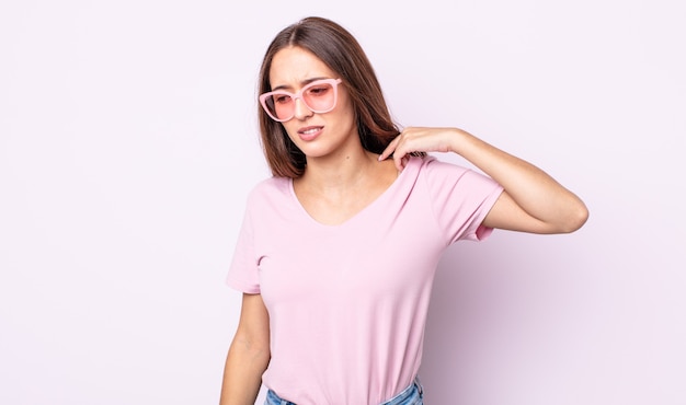 Mujer bonita joven que se siente estresada, ansiosa, cansada y frustrada. concepto de gafas de sol rosa