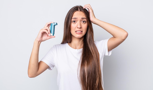 Mujer bonita joven que se siente estresada, ansiosa o asustada, con las manos en la cabeza. concepto de asma