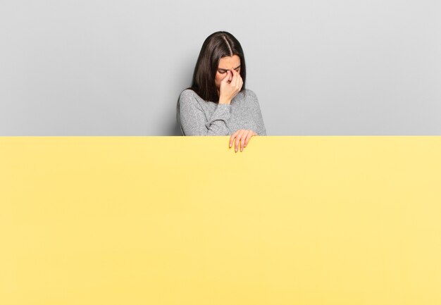 Mujer bonita joven que se siente estresada, infeliz y frustrada, toca la frente y sufre migraña de dolor de cabeza severo. copia espacio