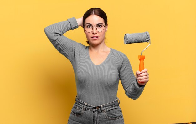 Mujer bonita joven que se siente estresada, preocupada, ansiosa o asustada, con las manos en la cabeza, en pánico por el error