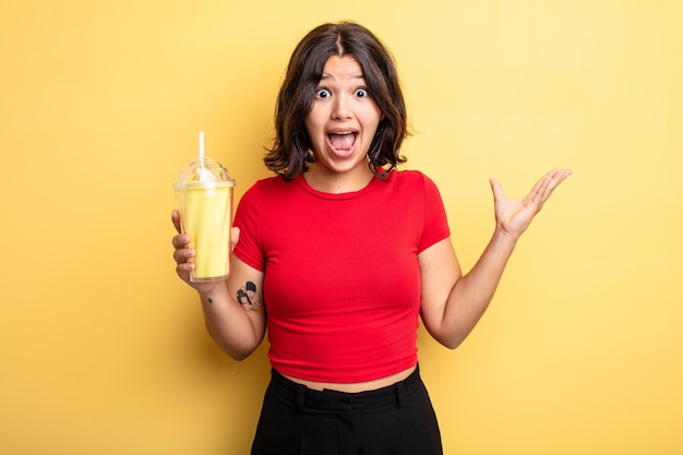 Mujer bonita joven que se siente feliz y asombrada por algo increíble. concepto de batido