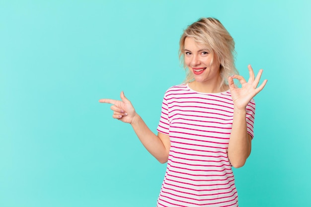 Mujer bonita joven que se siente feliz mostrando aprobación con el concepto de espacio de copia de gesto bien