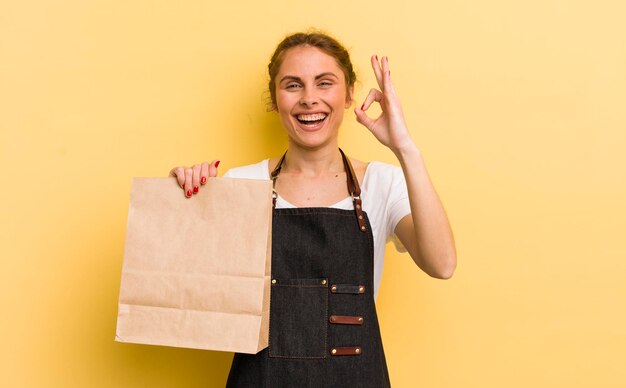 Mujer bonita joven que se siente feliz mostrando aprobación con gesto bien concepto de mensajería de comida rápida