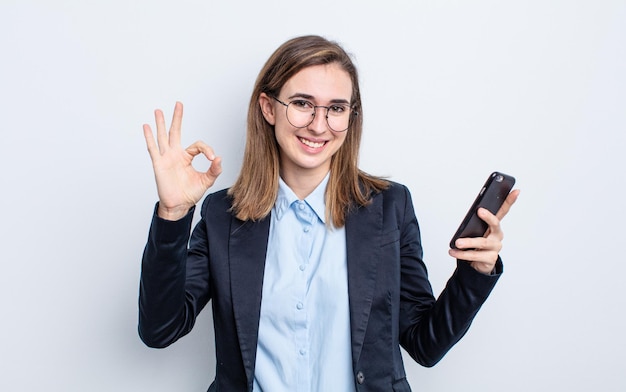 Mujer bonita joven que se siente feliz, mostrando aprobación con gesto bien. concepto de negocio