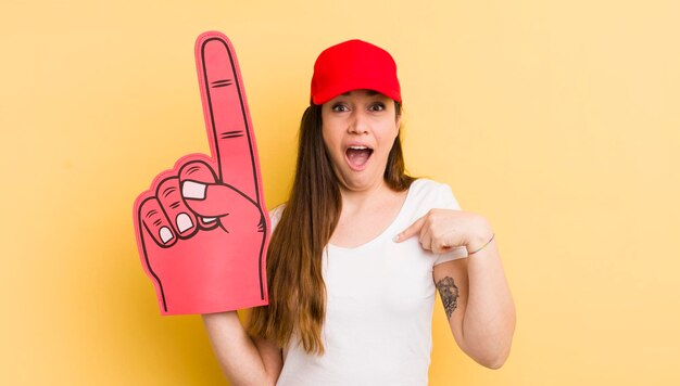 Mujer bonita joven que se siente feliz y se señala a sí misma con un concepto de mano número uno emocionado