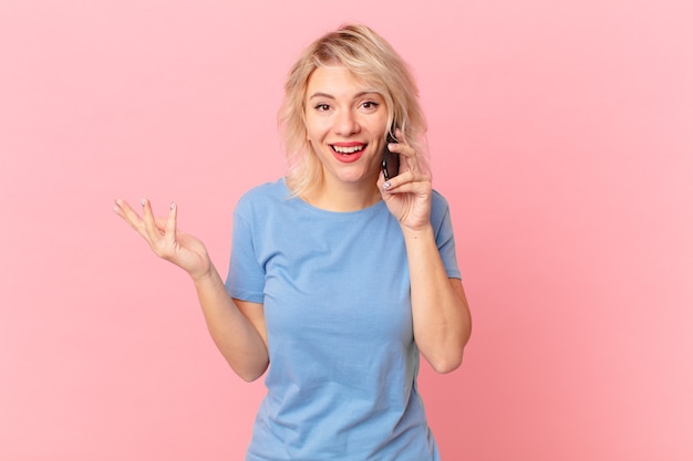 Mujer bonita joven que se siente feliz, sorprendida al darse cuenta de una solución o idea. concepto celular