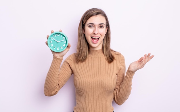 Mujer bonita joven que se siente feliz, sorprendida al darse cuenta de una solución o idea. despertador