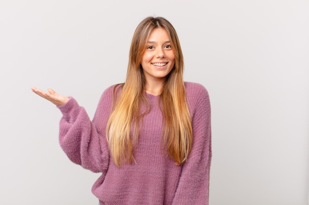 Mujer bonita joven que se siente feliz, sorprendida al darse cuenta de una solución o idea