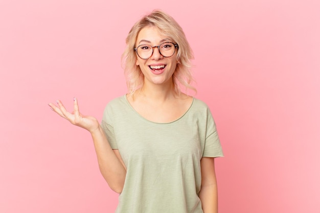 Mujer bonita joven que se siente feliz, sorprendida al darse cuenta de una solución o idea