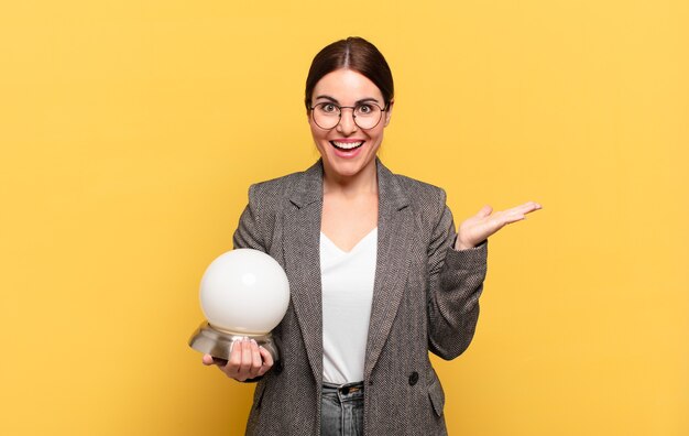 Mujer bonita joven que se siente feliz, sorprendida y alegre, sonriendo con actitud positiva, dándose cuenta de una solución o idea