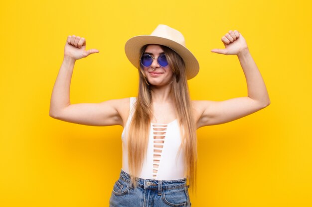 Mujer bonita joven que se siente orgullosa, arrogante y segura, que parece satisfecha y exitosa, apuntando a sí misma