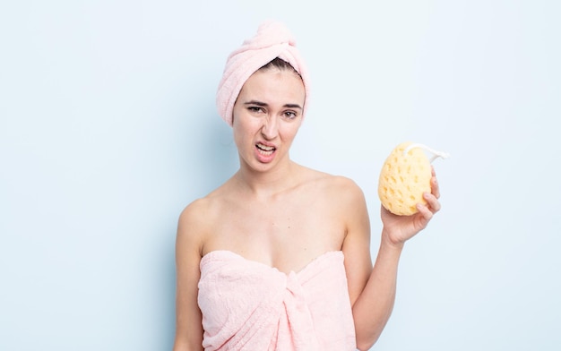 Mujer bonita joven que se siente perpleja y confundida. concepto de ducha y esponja