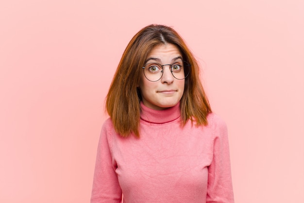 Mujer bonita joven que se siente triste y estresada, molesta por una mala sorpresa, con una mirada negativa y ansiosa en rosa