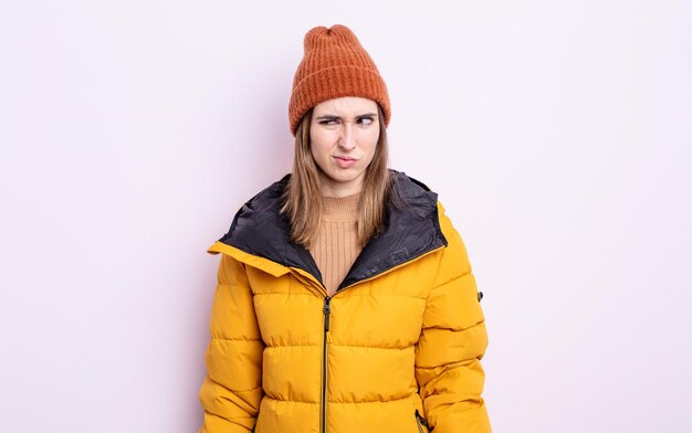 Mujer bonita joven que se siente triste, molesta o enojada y mirando hacia un lado. concepto de invierno