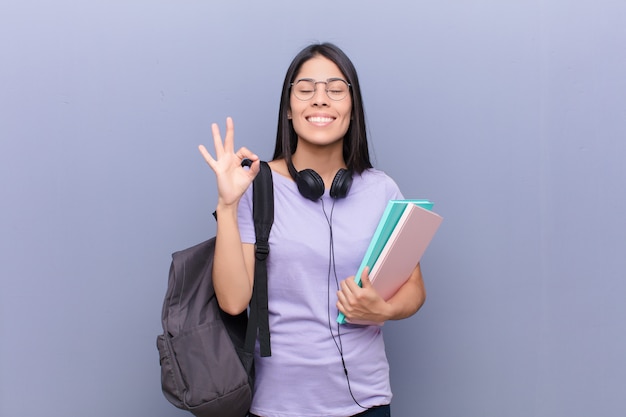 Mujer bonita joven que sostiene los cuadernos