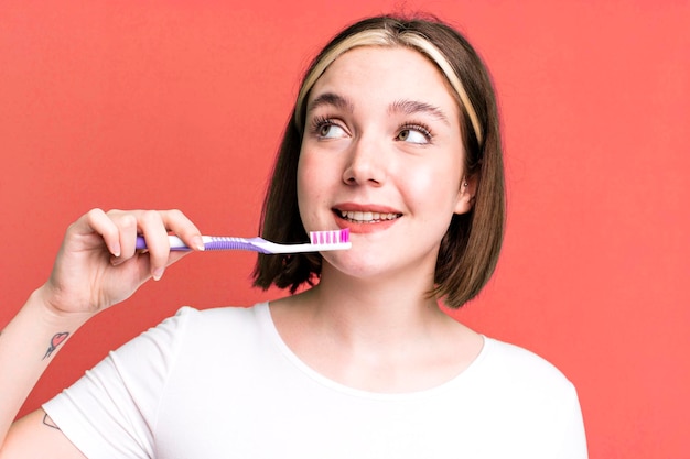 Mujer bonita joven que usa un cepillo de dientes