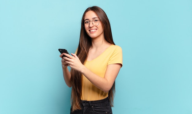 Mujer bonita joven que usa su celular.