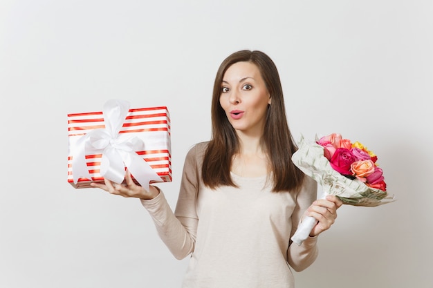 Mujer bonita joven con ramo de flores rosas hermosas, presente caja con regalo aislado sobre fondo blanco. Copie el espacio para publicidad. Concepto de día de San Valentín o día internacional de la mujer