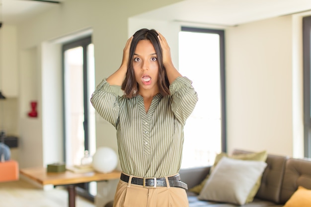 Mujer bonita joven relajándose en casa en un sofá