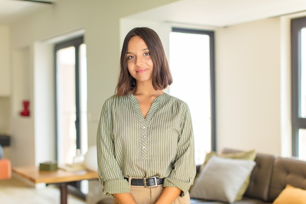 Mujer bonita joven relajándose en casa en un sofá