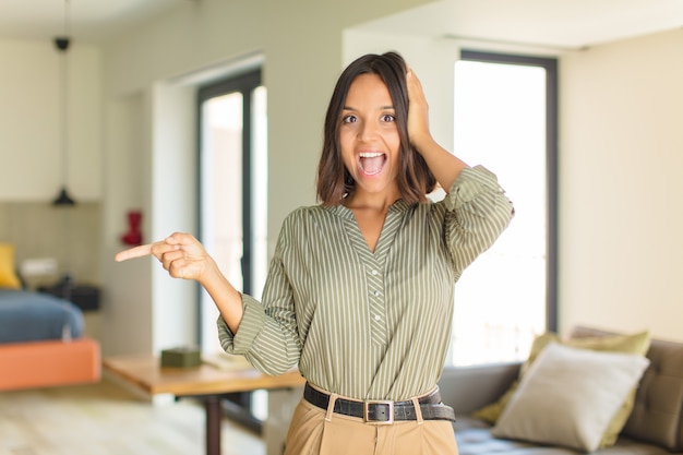 Mujer bonita joven relajándose en casa en un sofá