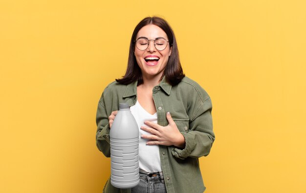 Mujer bonita joven riendo a carcajadas de una broma hilarante, sintiéndose feliz y alegre, divirtiéndose