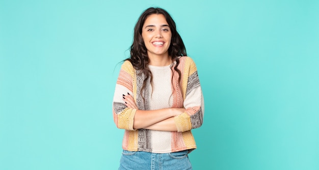 Mujer bonita joven riendo felizmente con los brazos cruzados, con una pose relajada, positiva y satisfecha