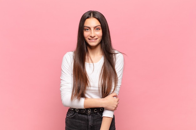 Mujer bonita joven riendo tímidamente y alegremente, con una actitud amistosa y positiva pero insegura