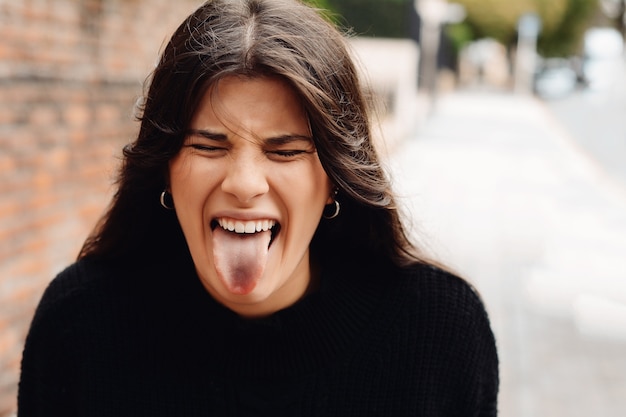 Mujer bonita joven sacando la lengua