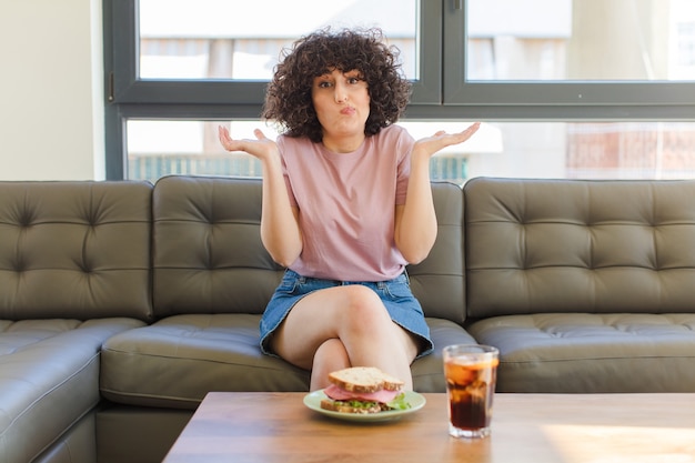 Mujer bonita joven con un sándwich