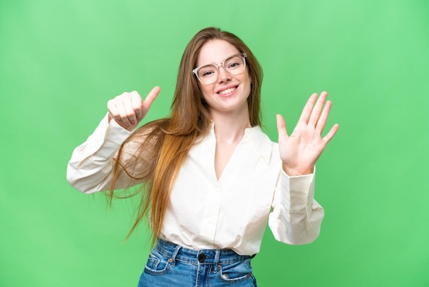 Mujer bonita joven sobre fondo clave de croma aislado contando seis con los dedos