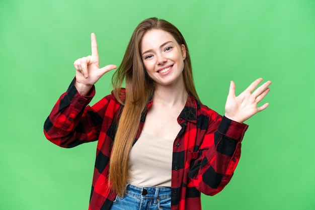 Mujer bonita joven sobre fondo clave de croma aislado contando siete con los dedos