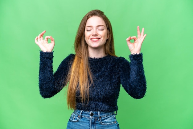 Mujer bonita joven sobre fondo clave de croma aislado en pose zen