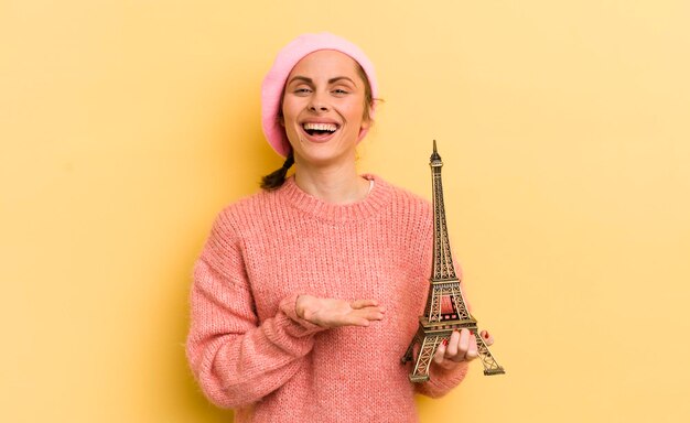 Mujer bonita joven sonriendo alegremente sintiéndose feliz y mostrando un concepto concepto de parís