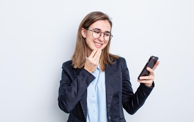 Mujer bonita joven sonriendo con una expresión feliz y segura con la mano en la barbilla. concepto de negocio