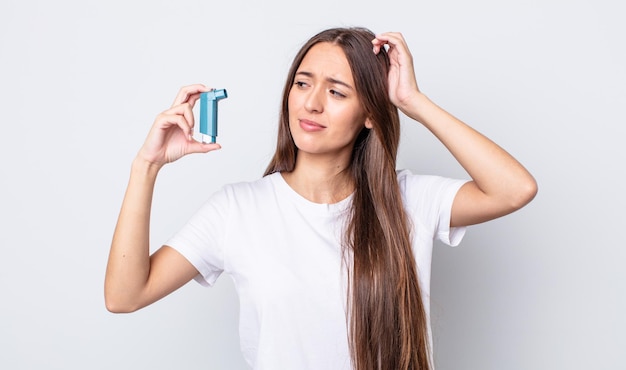 Mujer bonita joven sonriendo felizmente y soñando despierta o dudando. concepto de asma