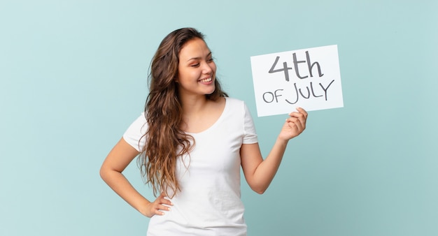 Mujer bonita joven sonriendo felizmente y soñando despierto o dudando del concepto del día de la independencia