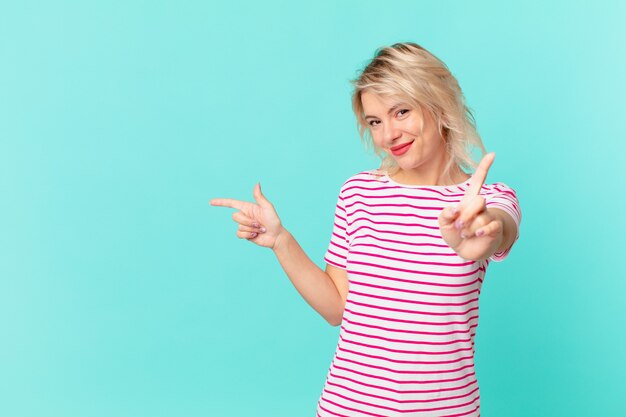 Mujer bonita joven sonriendo con orgullo y confianza haciendo el número uno. concepto de espacio de copia